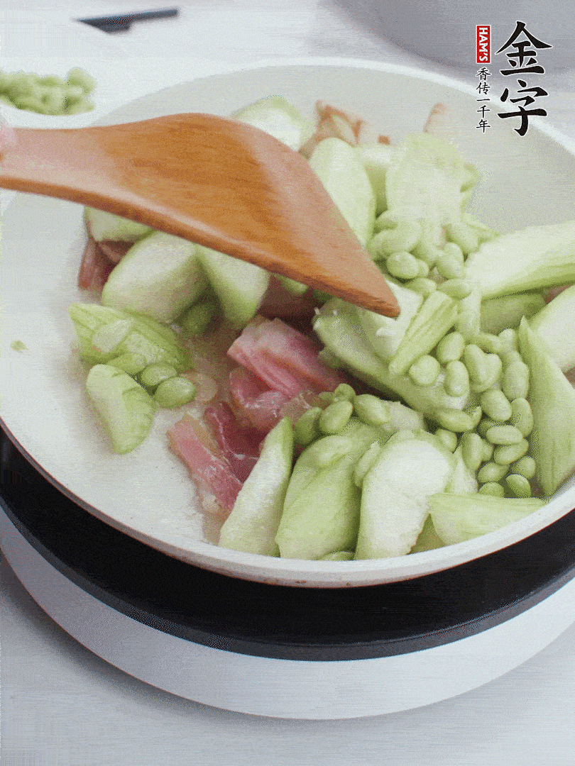 依次下絲瓜、青豆翻炒，炒至絲瓜打蔫縮小。